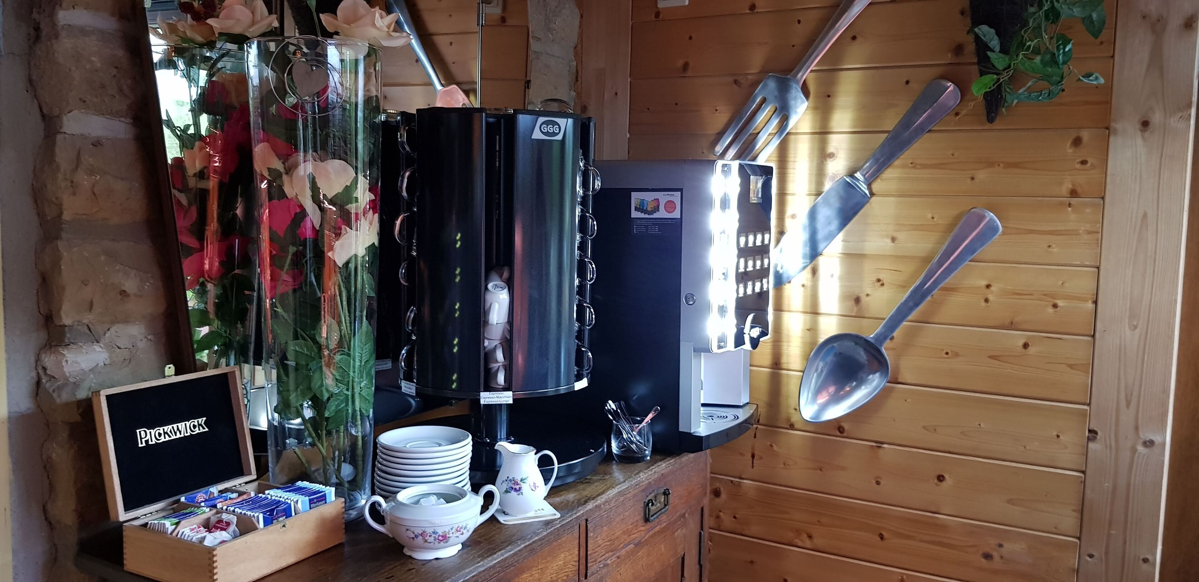 Ein Küchenbereich mit Kaffeemaschine, Geschirr und einem Schild mit der Aufschrift "Pickwick".