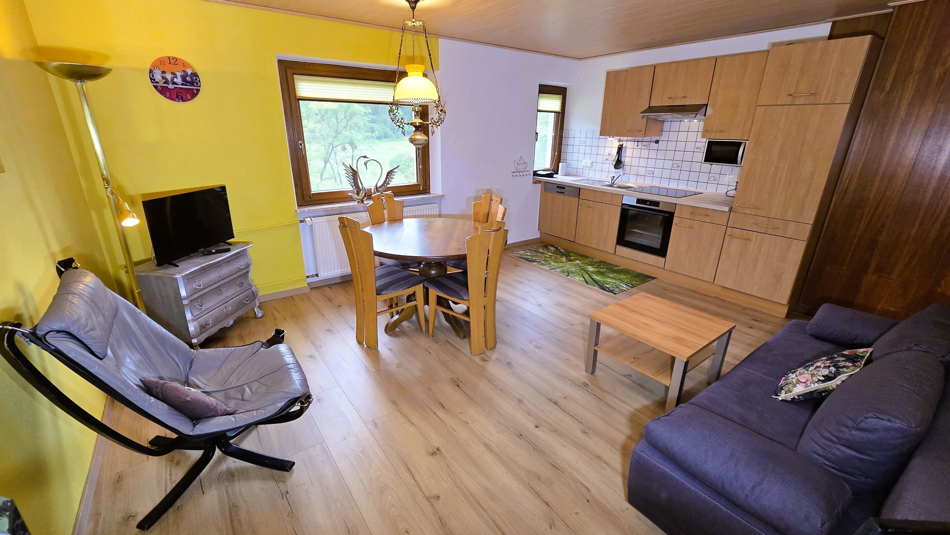 A compact living space with a dining area, kitchenette, and seating arrangements.