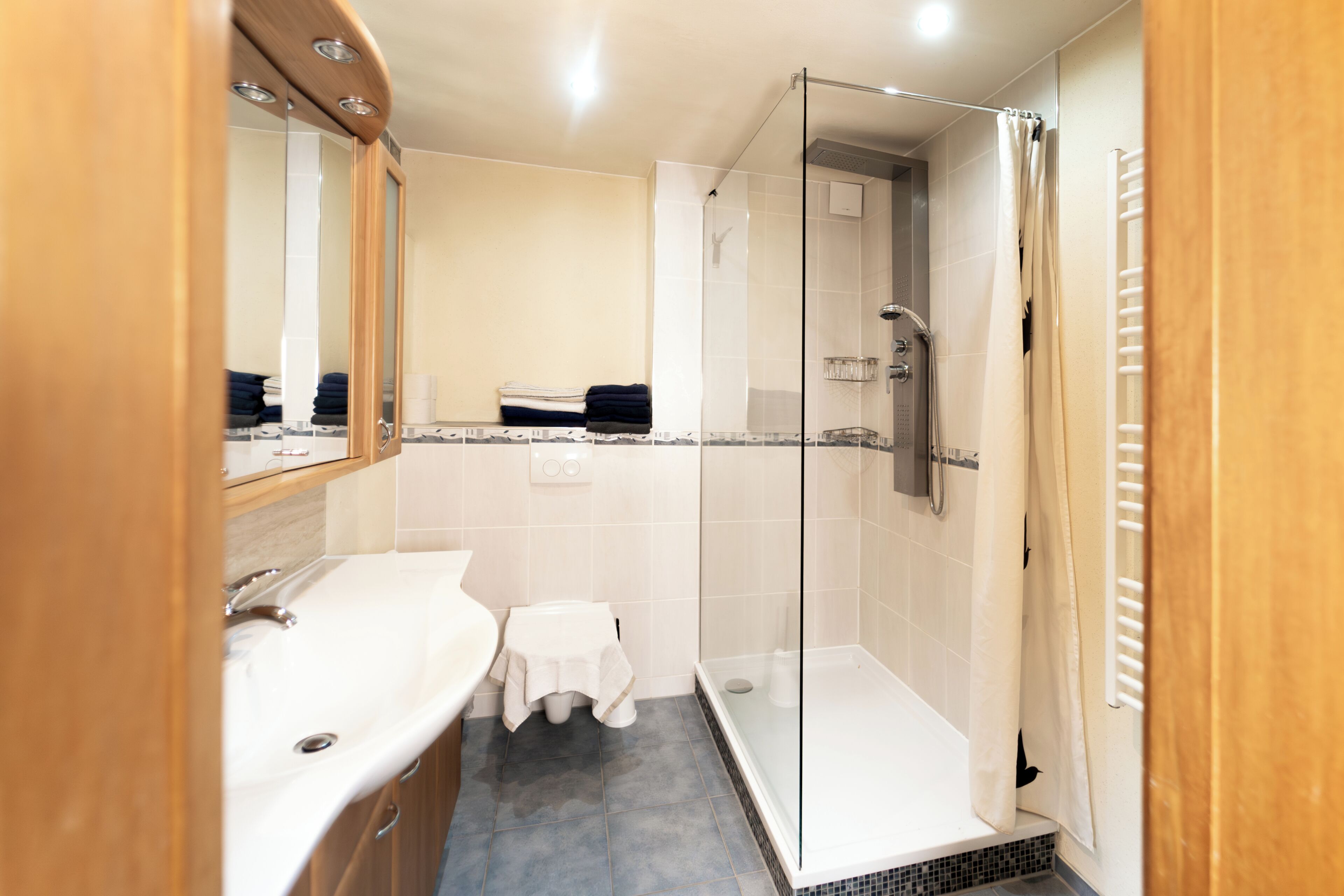 Un baño moderno con ducha acristalada, lavamanos e inodoro.