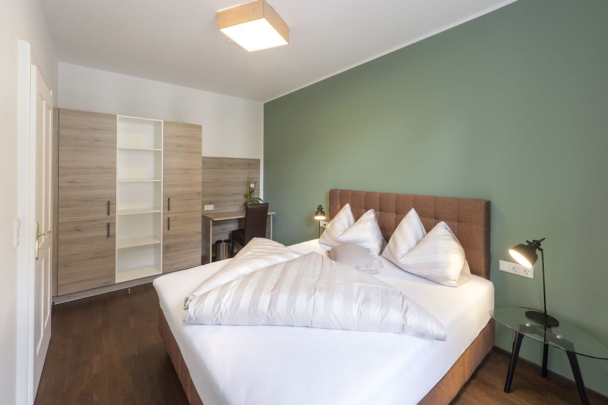 Une chambre avec un grand lit, un bureau et une armoire.