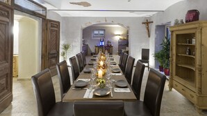 A dining area with a long table set for a meal, surrounded by chairs. - Villa Maria - Suiten & Appartements (Kufstein)