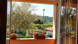 A balcony with a view of a garden and a building. - Apartment Kalin (Piran)