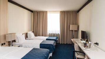 Une chambre d’hôtel avec deux lits, un bureau avec un ordinateur, une chaise, une télévision et un mini-bar.