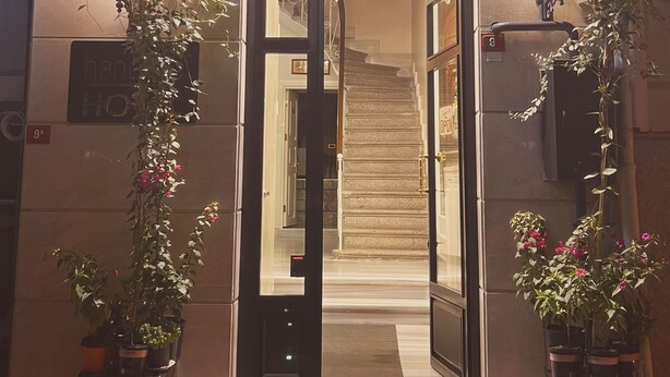 The entrance of a hotel with a sign reading "hanende HOTEL".