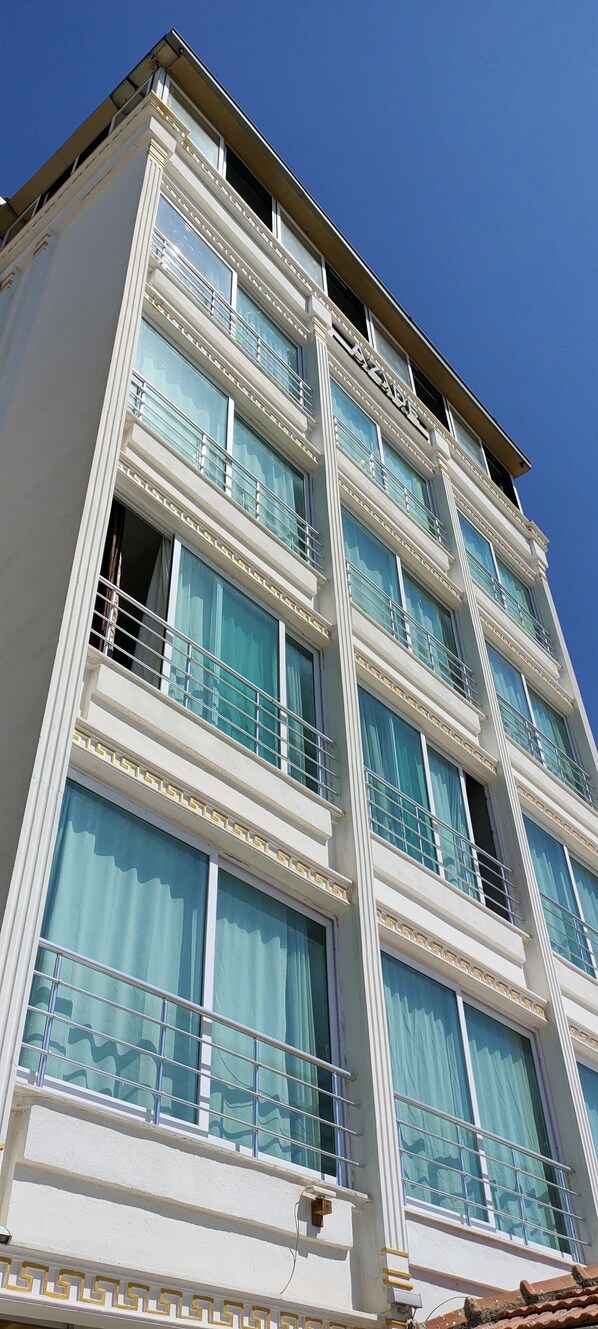 Classic hotel building with ornate moldings and large windows.