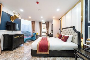 A hotel room with a large bed, a television, a desk, and a view of the city. - Collection O Havana Airport Hotel (Ho Chi Minh City)