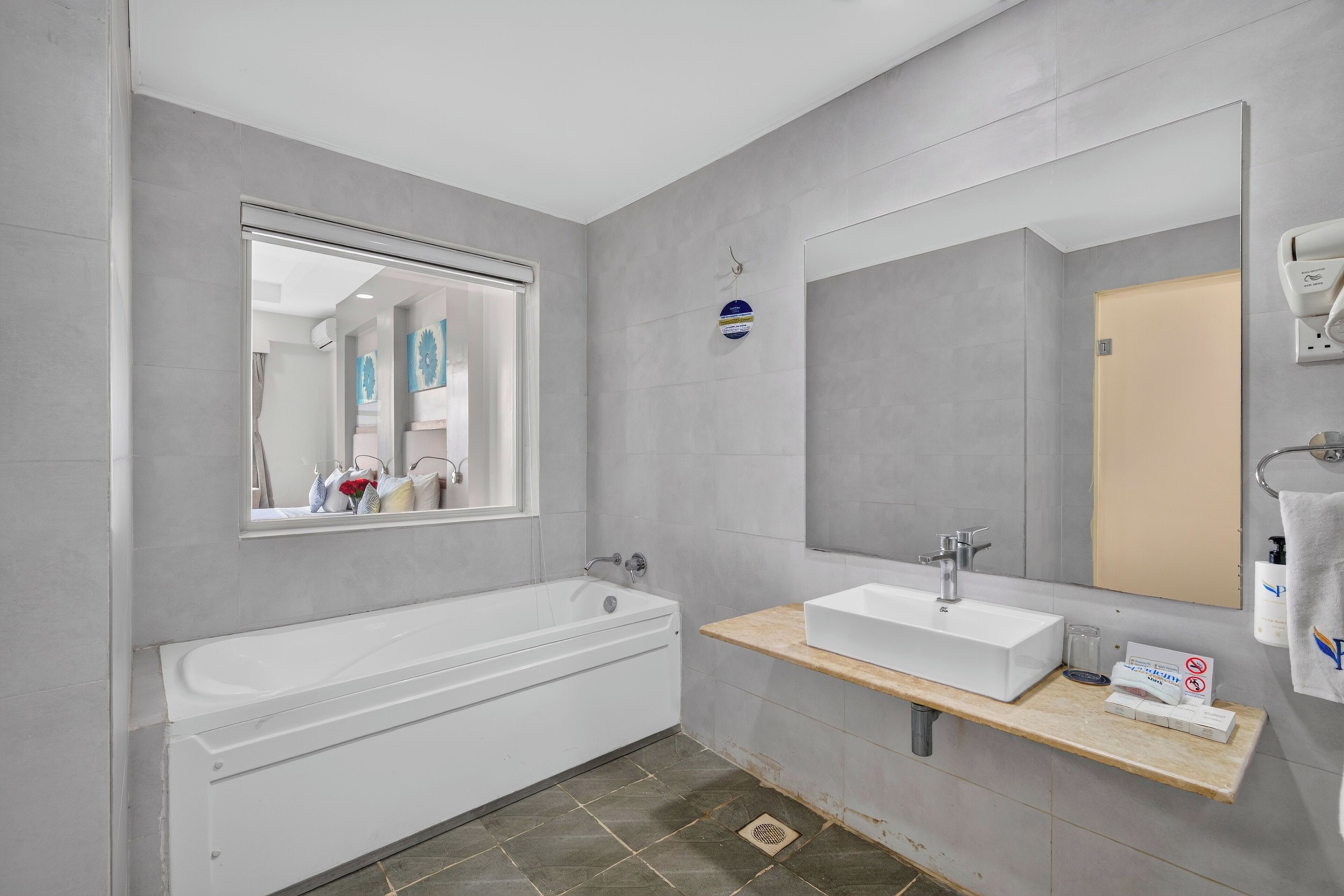 A modern bathroom with a bathtub, a sink, and a large mirror.