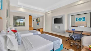 A hotel room with two beds, a desk, a chair, a TV, and a window with a view.