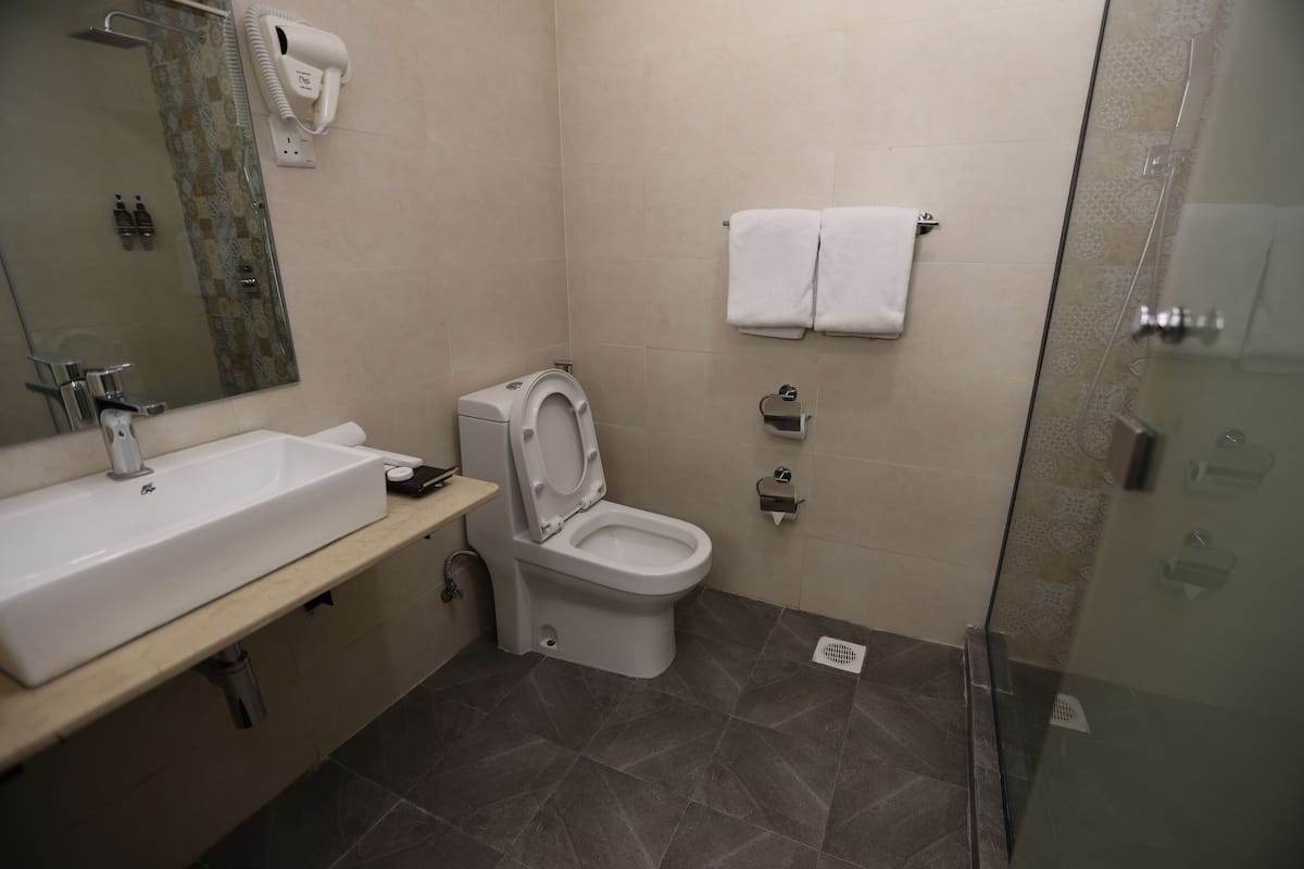 Un baño moderno con lavamanos, inodoro y ducha.