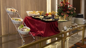 A buffet setup with various dishes and a floral arrangement. - Hotel Deep Clarks Inn Lucknow  (Lucknow)