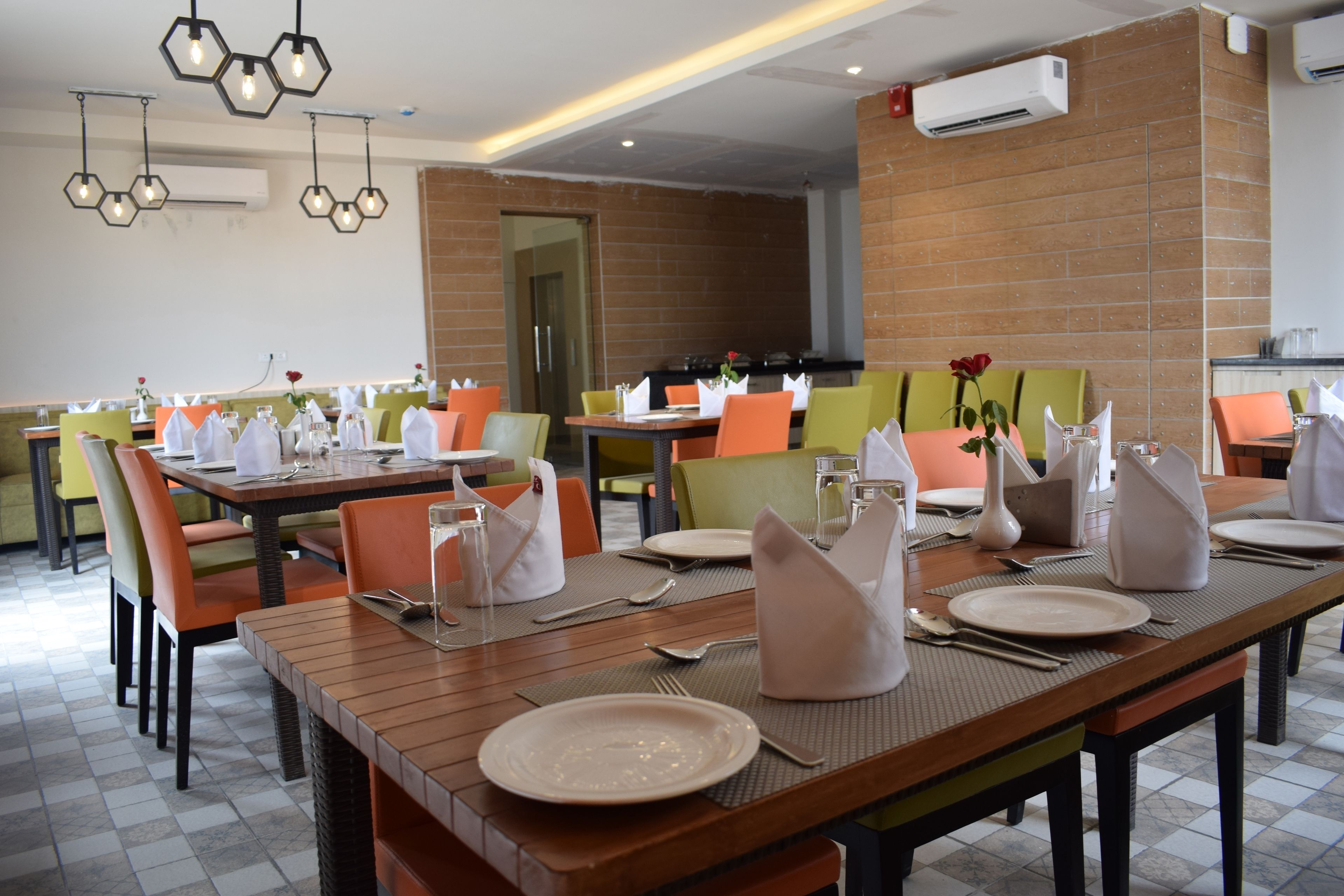 A dining area with multiple tables set for meals, featuring a mix of chairs and a central dining table.