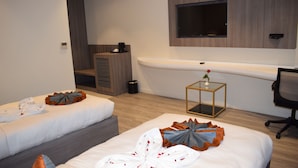 A hotel room with two beds, a TV mounted on the wall, a small table with a vase, and a chair. - Hotel Deep Clarks Inn Lucknow  (Lucknow)