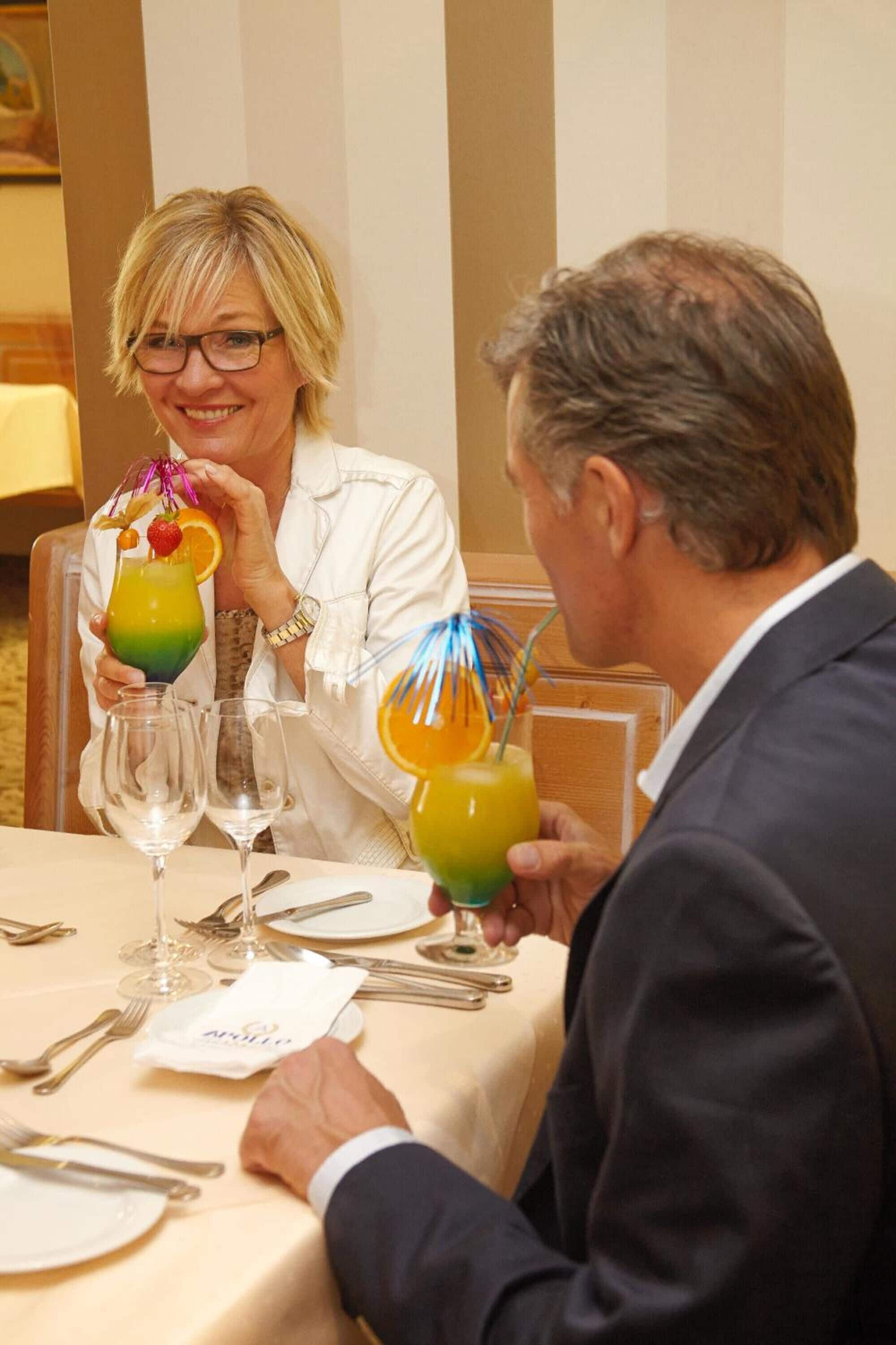Une table à manger dressée avec plusieurs verres, des couverts et une serviette.
