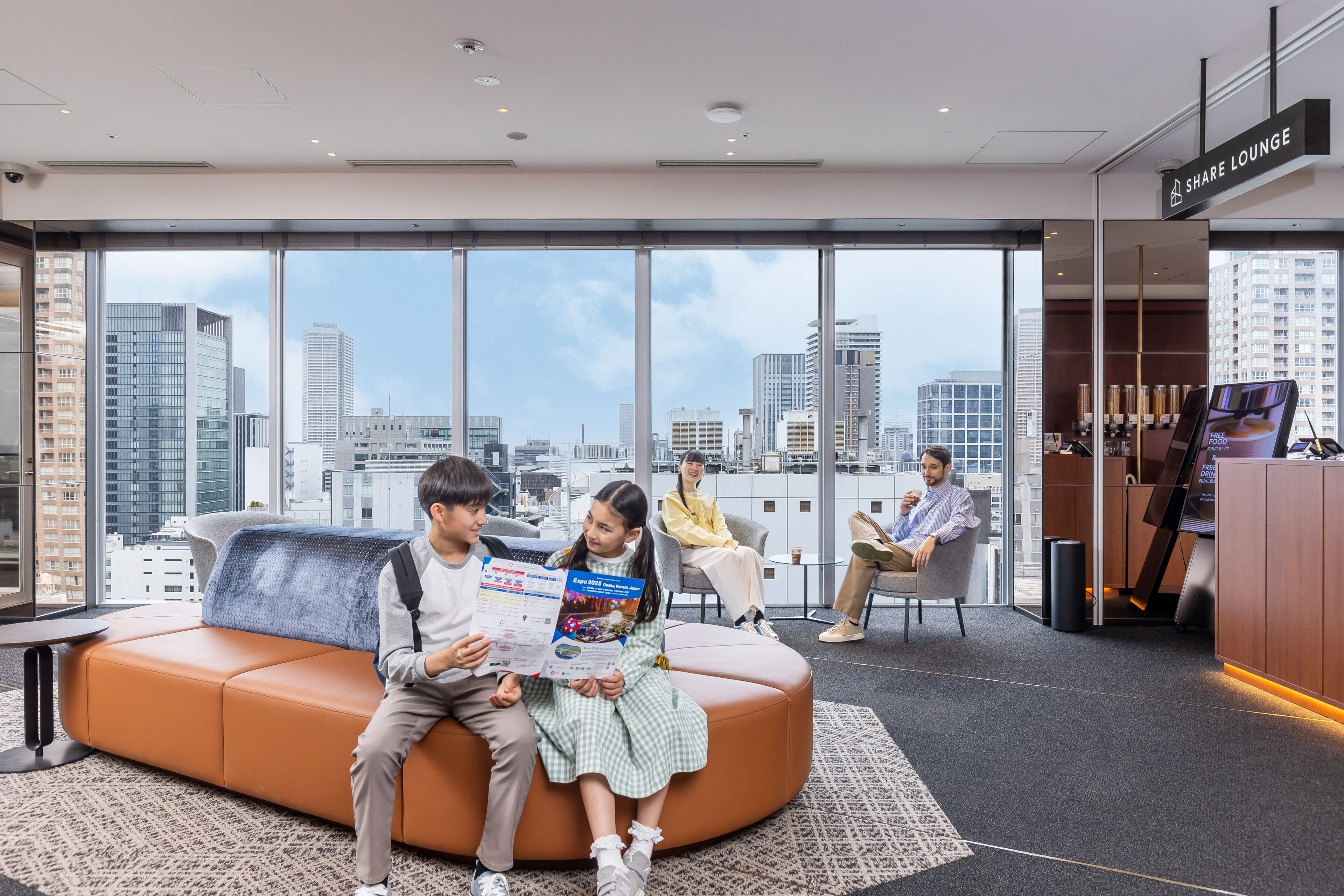 A modern lounge area with a large window offering a city view, a seating area with a sofa and chairs, and a reception desk.