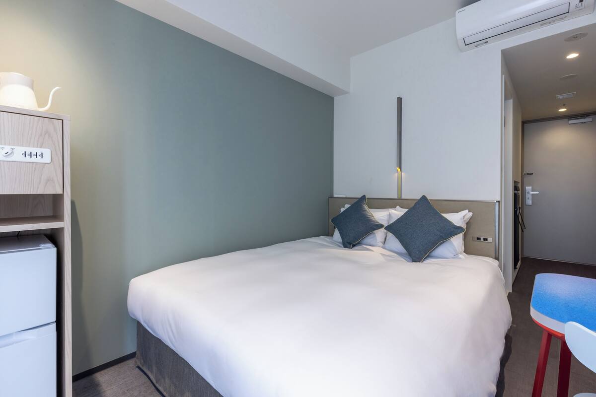 Ein Hotelzimmer mit Bett, Schreibtisch und Stuhl.