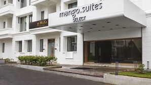 A modern building with a sign for 'Mango Suites Select' and a 'MoX Bistro' sign.