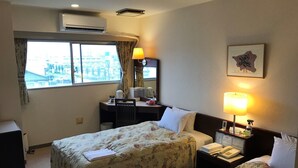 A hotel room with two beds, a desk, a chair, a lamp, a telephone, and a window with curtains. - Yamanashi Grand Hotel (Chuo)
