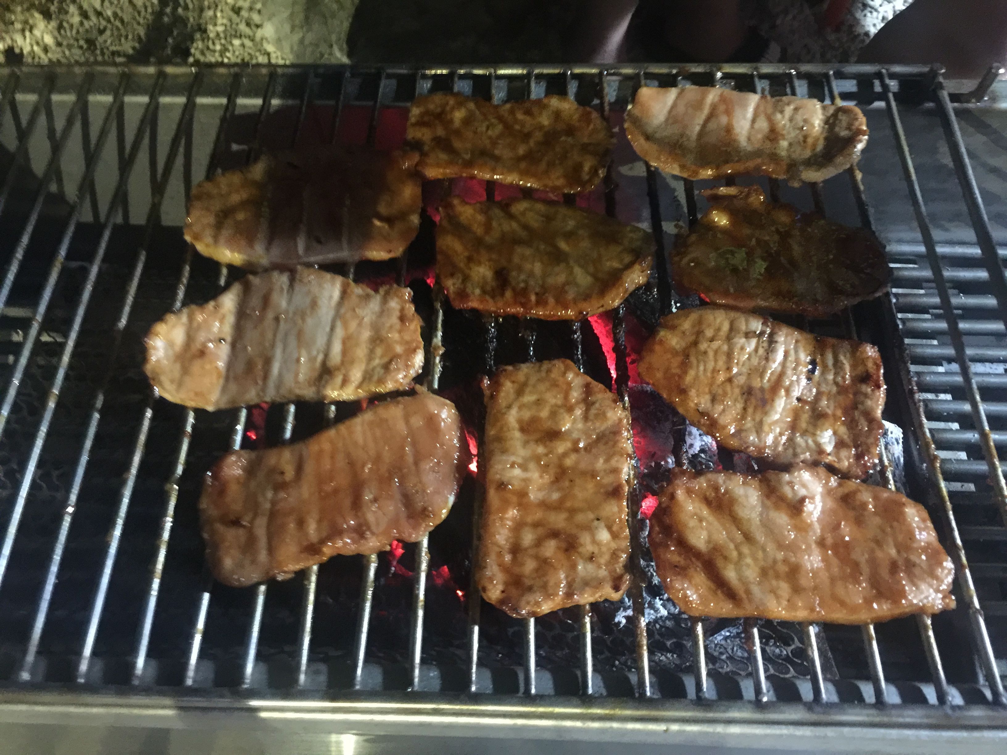En grill med flere stykker kød, der tilberedes over åben ild.