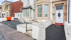 A residential building with a white facade, a red brick section, and a white door with a number plaque. - Cherry Property - Apple Suite (Blackpool)