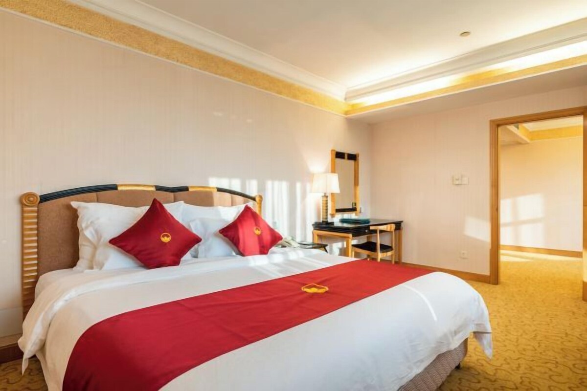 Ett hotellrum med en säng, ett skrivbord och en stol.