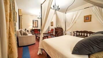 Une chambre à coucher avec un lit à baldaquin, un canapé, un bureau et une chaise.