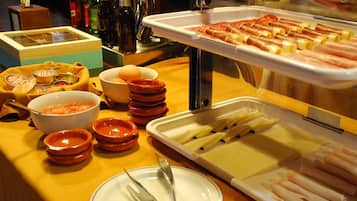 Un bufé con diversas opciones de comida, incluyendo carnes, quesos y salsas.