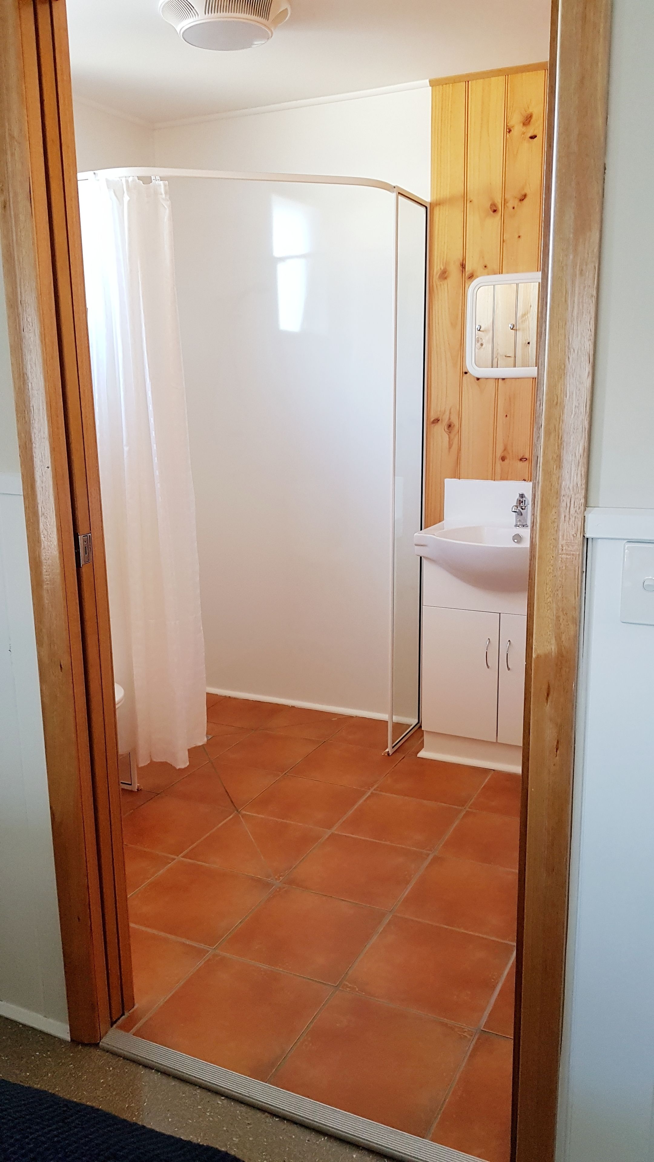 Une salle de bain avec une douche, un lavabo et des placards.