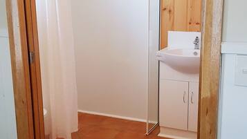 Une salle de bain avec une douche, un lavabo et des placards.