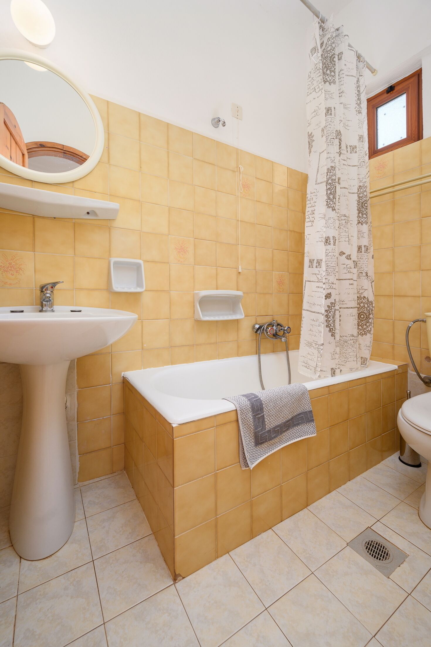 Un baño con bañera, lavabo, espejo y cortina de ducha.