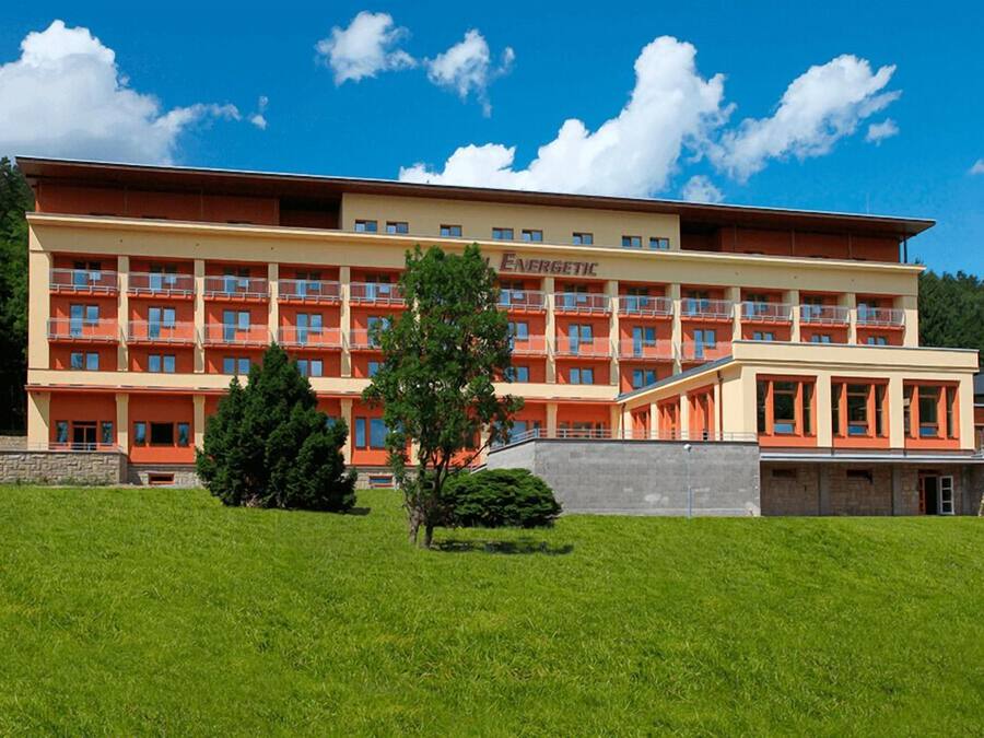 Un hotel de varios pisos con techo plano y balcones, y un letrero que dice "ENERGETIC".