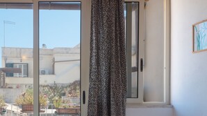 Ein Essbereich mit Tisch für vier Personen, einem Stuhl und Blick auf die Stadt durch ein Fenster.