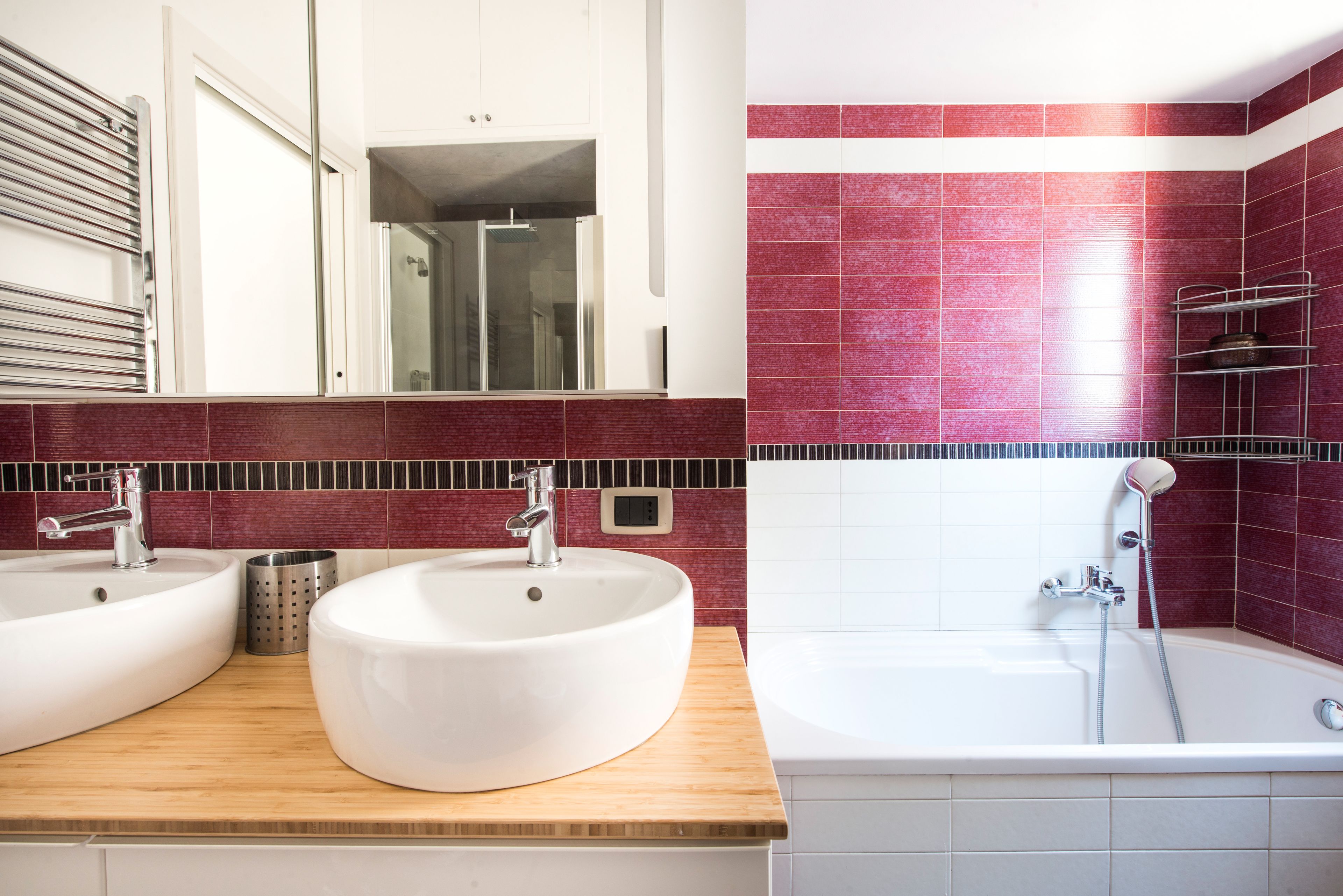 A bathroom with two sinks, a shower, and a wooden countertop.