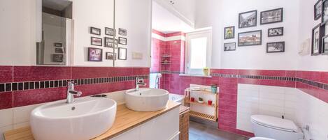 Une salle de bain moderne avec deux lavabos, des toilettes et un grand miroir.