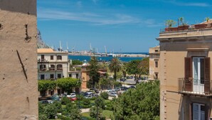 A coastal town with buildings, parked cars, and a clear view of the sea and port in the background. - Terrazza dei Colori alla Kalsa by Wonderful Italy (Palermo)