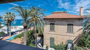 Un bâtiment situé sur la côte, doté d’un toit recouvert de tuiles, d’une piscine et de palmiers.