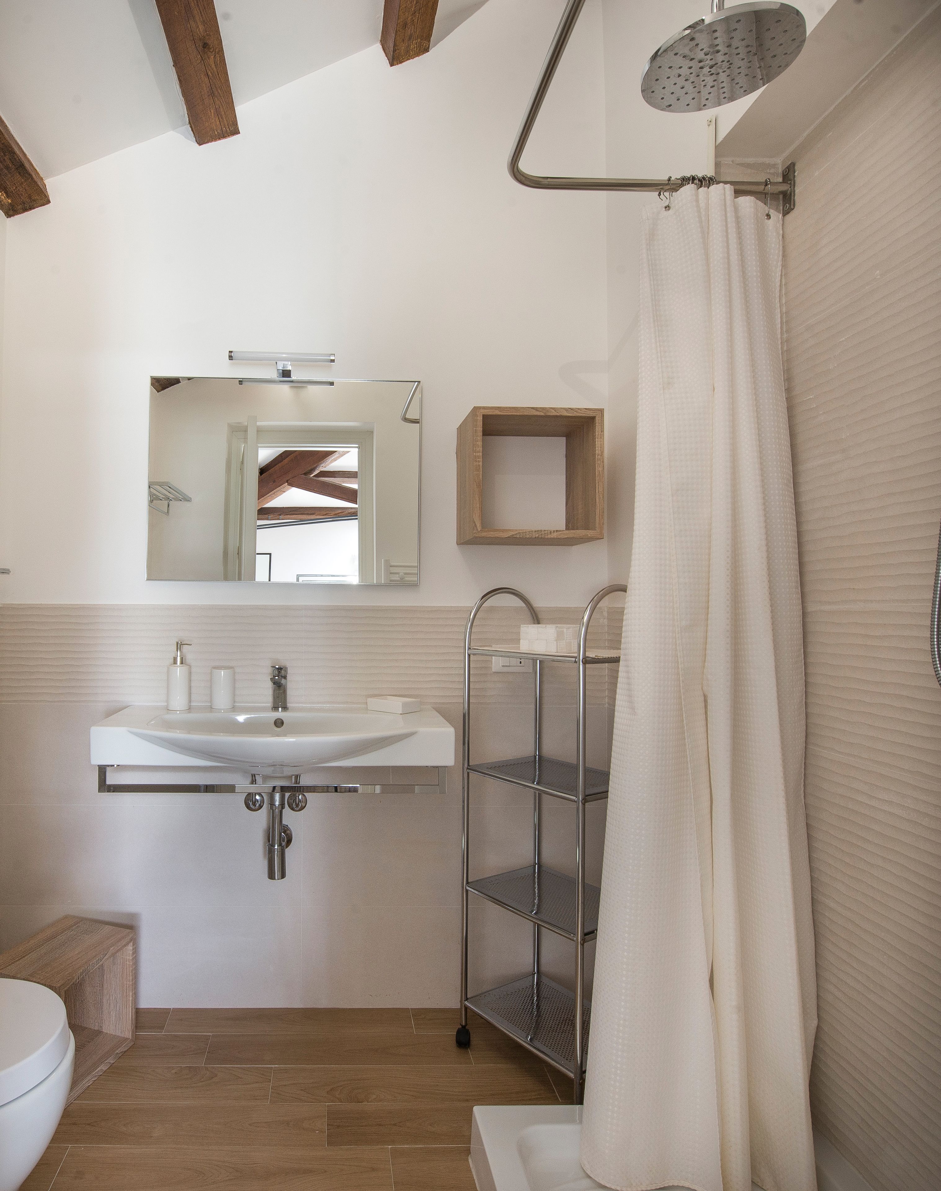Ein modernes Badezimmer mit Waschbecken, Spiegel und Dusche.