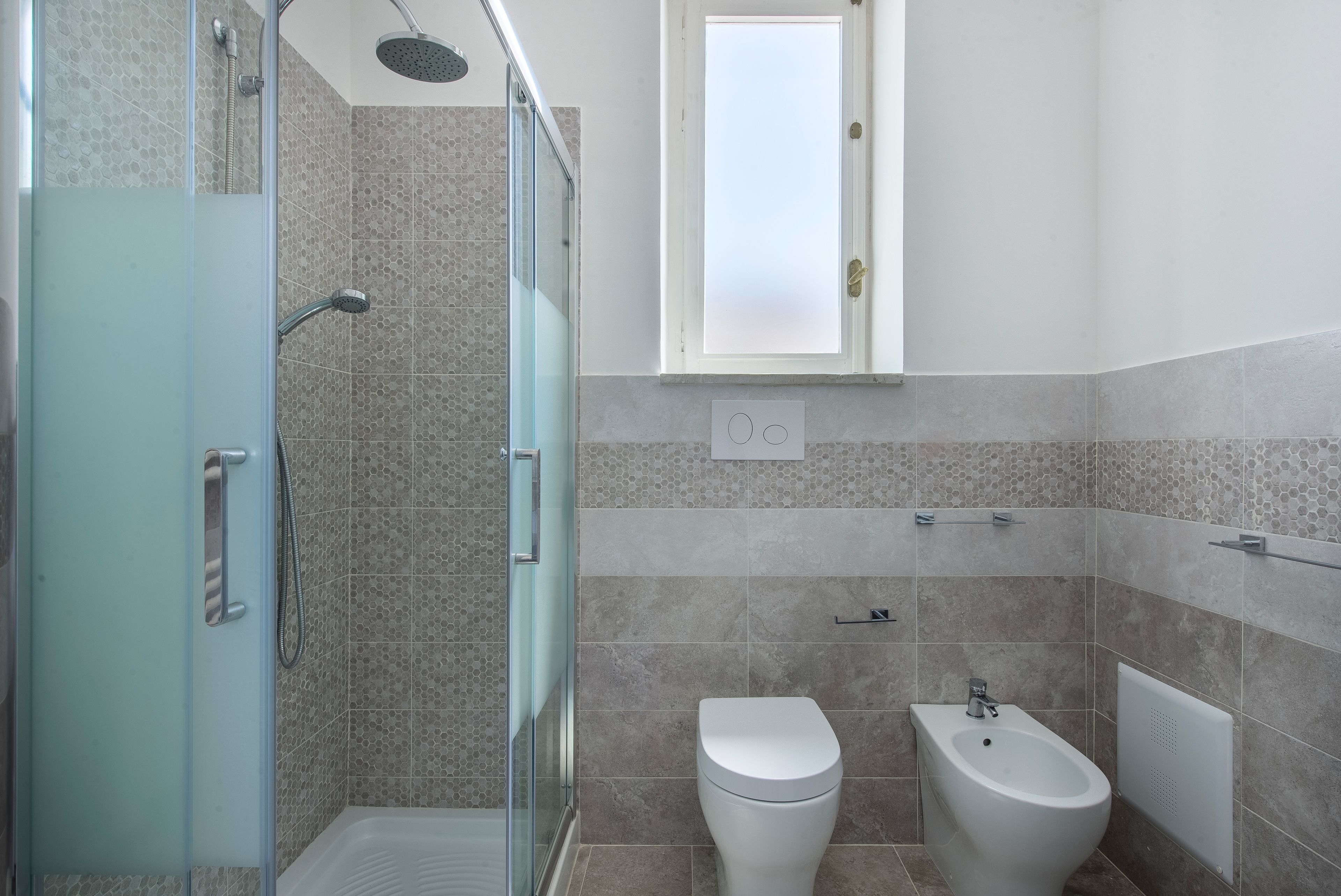 Ein modernes Badezimmer mit Duschkabine aus Glas, Toilette und Bidet.
