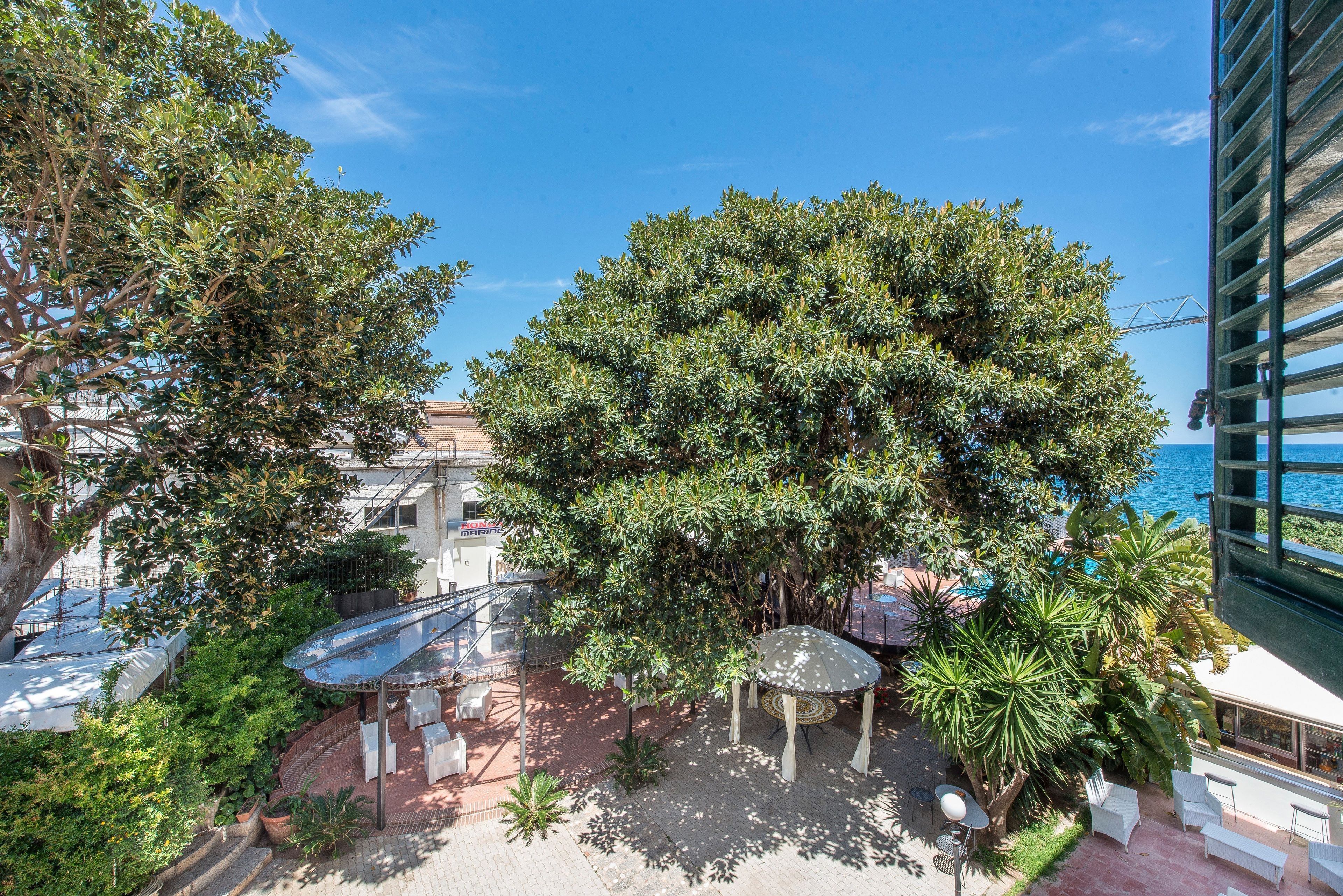 A rooftop garden with a gazebo, outdoor seating, and a view of the sea.