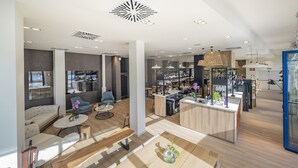 A modern hotel lobby with a seating area, a bar, and a reception desk. - Hotel Voramar (L'Escala)