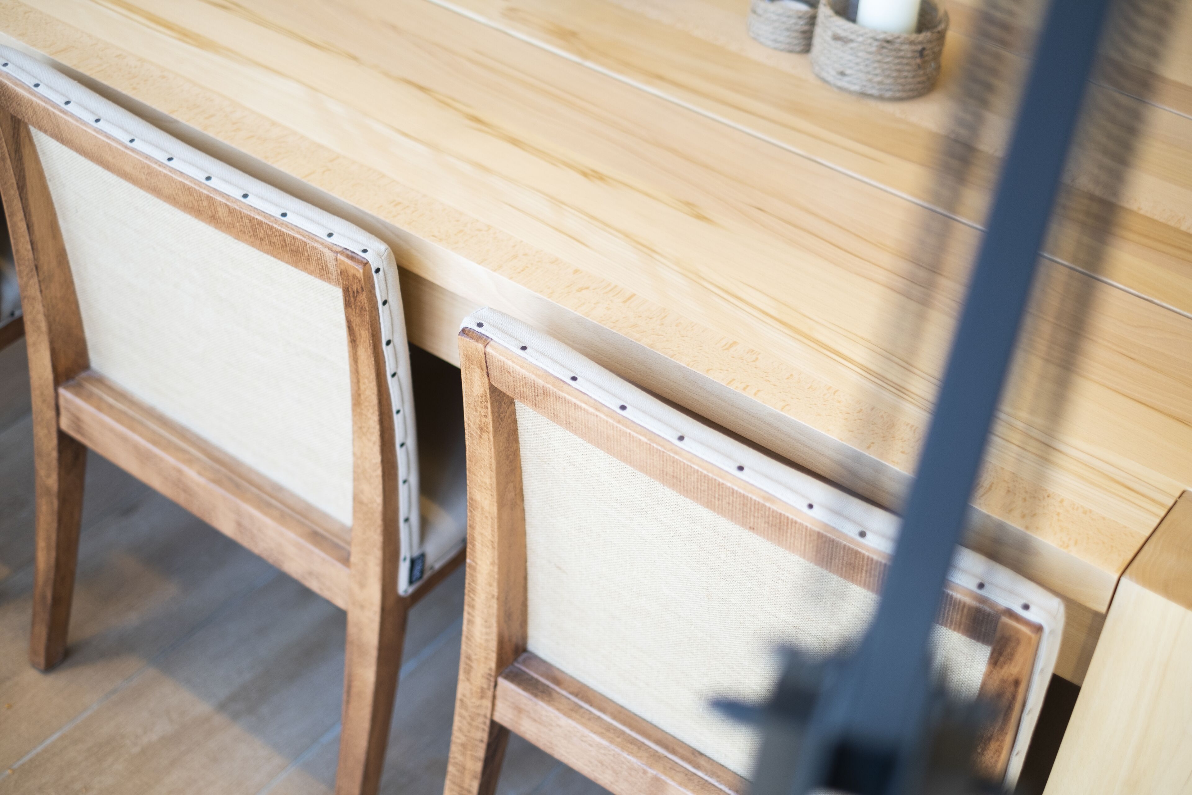 Ein Holztisch mit einem Stuhl, dessen Rückenlehne und Sitzfläche aus Bändern geflochten sind.