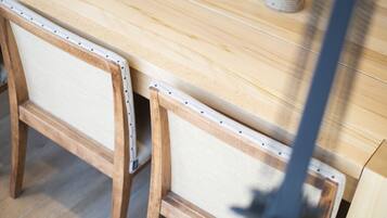 Una mesa de madera con respaldo y asiento de silla tejido.