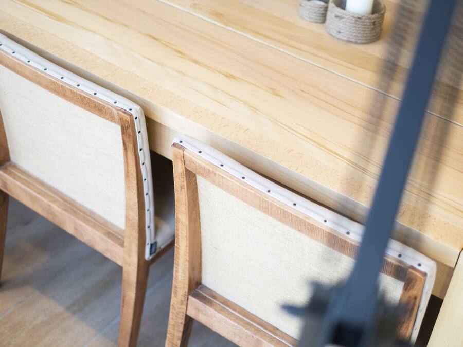 Una mesa de madera con respaldo y asiento de silla tejido.