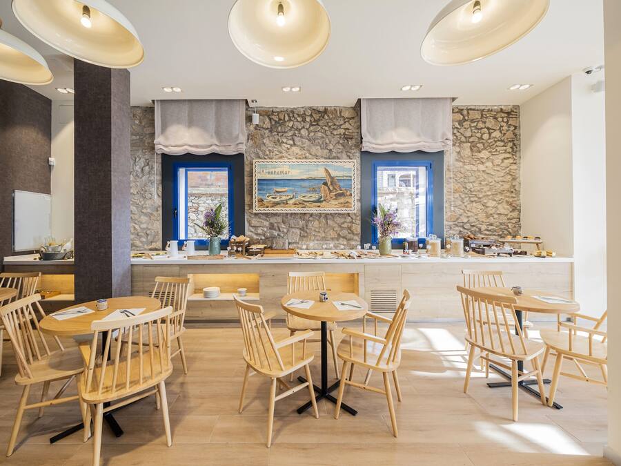 Ein Restaurant mit Holztischen und -stühlen, Steinwänden und einem Gemälde mit einer Strandansicht.