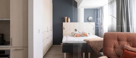 Un dormitorio moderno con una cama, una silla y un escritorio.