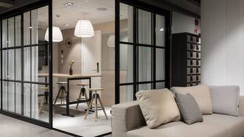 Un interior moderno con un sofá, una zona de comedor y una estantería.