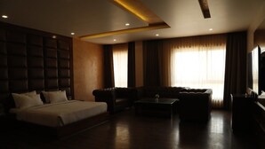 Une chambre d’hôtel avec un grand lit, un canapé, une petite table et un téléviseur.