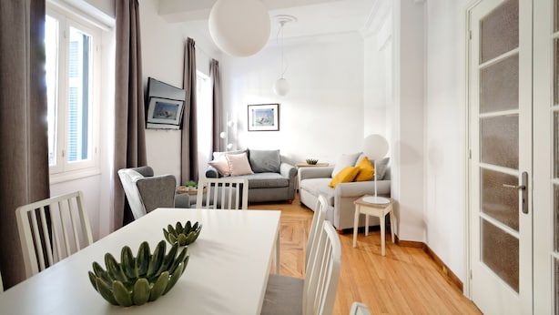 A modern living room with a dining area, white walls, and a wooden floor. - Art in Athens Suite (Athens)