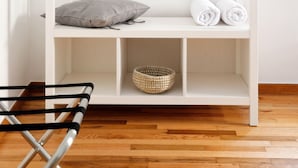 A white walk-in closet with a hanging rod, shelves, and a basket. - Art in Athens Suite (Athens)