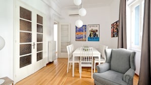 A modern living room with a dining area, white furniture, and artwork on the walls. - Art in Athens Suite (Athens)