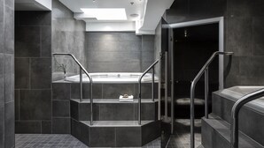 A modern bathroom with a freestanding bathtub, a glass shower enclosure, and a staircase with metal railings. - Noli Sörnäinen (Helsinki)